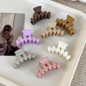 Set mit 7 matten Mini-Haarklammern in Erd- und Macaron-Tönen auf einem Tablett