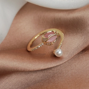 Macro detail of tulip pearl ring with pink gemstone and zircon-encrusted golden band
