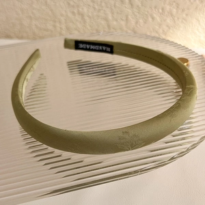 Detail of light green satin headband with floral jacquard and handmade inner label