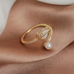 Detailed macro view of a gold-plated tulip ring with opal, pearl and micro diamonds