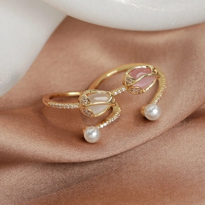 Macro shot of gold tulip ring with pink gems, sparkling pavé diamonds and white pearls