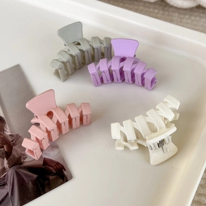 Nahaufnahme von 4 matten Mini-Haarklammern in Pastellfarben wie Rosa, Lila und Weiß