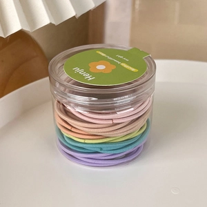 Detail of multi-color high elastic hair bands in a transparent cylindrical storage jar
