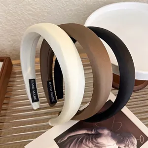 Three wide satin sponge headbands in cream, brown, and black colors with handmade labels