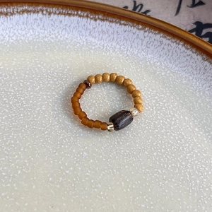 Close-up of handmade beaded ring with stone and wood beads in retro ethnic style