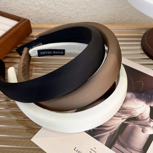 Close-up of three satin sponge headbands in black, brown and white with non-slip lining