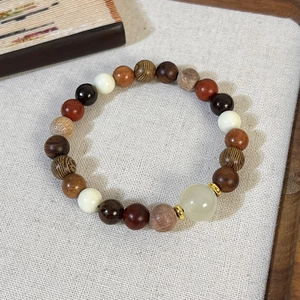 Gros plan de perles en bois de santal avec accents de jade sur lin gris