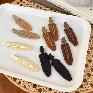 Detailed view of ten matte resin hair clips in brown and coffee gradients on a tray