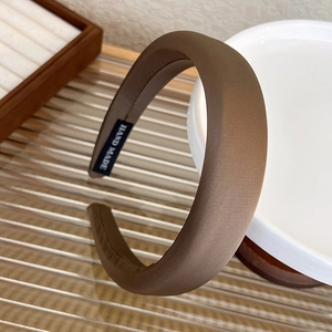 Detailed close-up of a handmade brown satin headband with high-top sponge padding
