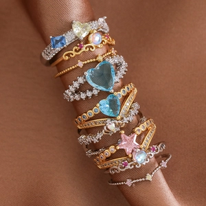 Detailed macro view of gold and silver plated heart and star rings with colorful crystals