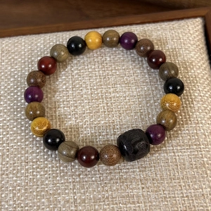 Vue macro d'un bracelet en bois de santal avec perle gravée et textures de bois mixtes
