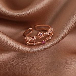 Detail of rose gold double layer crown ring with pink heart stone on brown silk