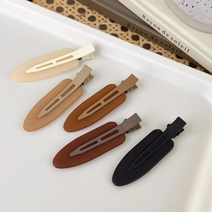 Five-piece set of matte resin hair clips in earthy brown tones on a white tray