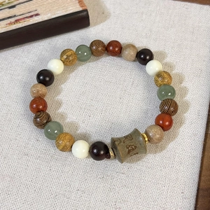 Détail macro de perles en bois de santal chinois avec mantra gravé sur fond de lin