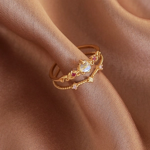 Macro shot of gold-plated two-piece ring set with opal stone and delicate V-shaped band