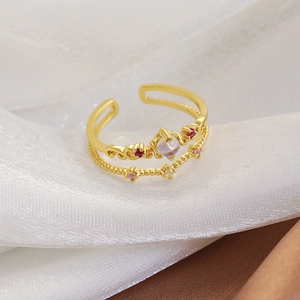 Macro shot of double-layered gold ring with blue moonstone and pink micro-pavé zircons