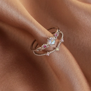 Macro detail of silver ring set featuring opal center stone and micro-pave crystals