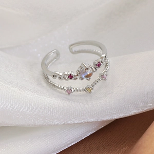 Macro shot of double layered open ring with colorful zircon and moonlight stone inlay