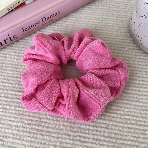 Detailed macro view of magenta knit towel fabric scrunchie with soft pleated texture