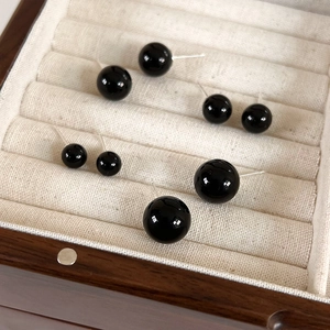 Elegant black bead stud earrings set in various sizes displayed in a premium beige jewelry box