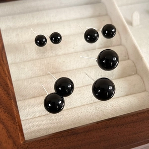 Elegant black bead stud earrings in various sizes displayed on a premium beige velvet tray