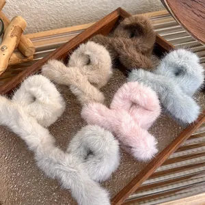 Plush faux fur hair claws in warm candy colors set on elegant wooden display tray