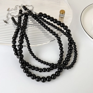 Detail of multi-layer black glass bead necklace with silver lobster clasp and extension chain