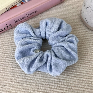 Close-up of lilac and light blue scrunchies in towel fabric with metal charm
