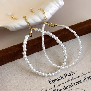 Detail of elegant French style white pearl strand necklace with gold lobster clasp
