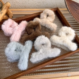 Macro shot of six assorted soft plush faux fur hair claw clips in warm autumn candy colors