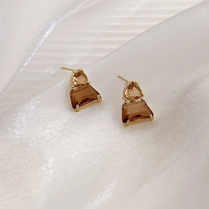 French amber crystal glass earrings with gold metal base on white fabric background