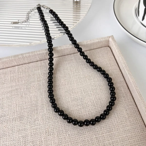 Close-up of black glass bead necklace with silver lobster clasp and extension chain
