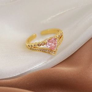 Close-up of golden ring with heart-shaped pink zircon and double micro-paved bands