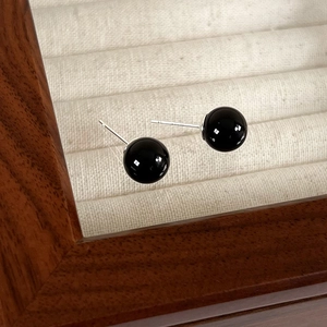 Detail of round black onyx stud earrings with polished 925 sterling silver posts