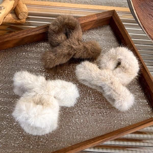 Detailed view of three large plush hair claws in soft brown, coffee and cream faux fur