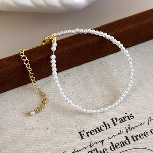 Detail of small faux pearl bracelet with golden lobster clasp on a velvet stand