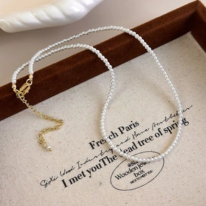 Close-up of elegant pearl necklace with gold lobster clasp and adjustable extender chain