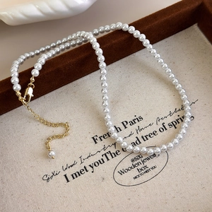 Close-up of pearl necklace with gold lobster clasp and adjustable extension chain
