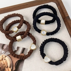 Elegante Katzenaugenstein-Haargummis in Schwarz und Braun mit Goldblumen-Anhängern