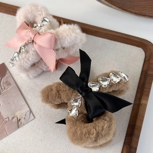 Detail of plush bow hair claws with sparkling crystals on a wooden decorative tray