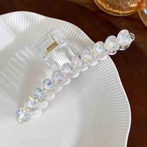 Nahaufnahme der herzförmigen Glitzer-Pailletten im transparenten Acryl-Haarclip