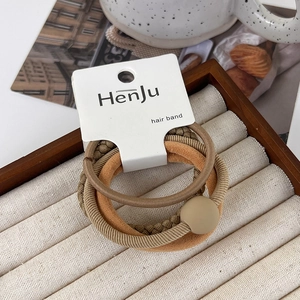 Detail of khaki hair band set featuring beaded, braided, and ribbed textures on a tray