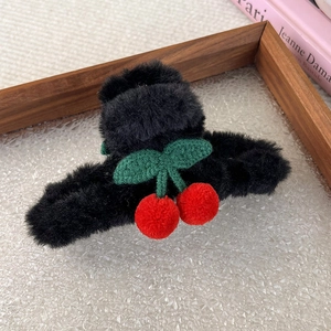 Dettaglio della pinza per capelli in peluche nero con ciliegie rosse e foglie lavorate