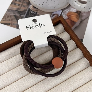 Detailed view of 4-piece hair band set with brown ribbed and beaded designs on card