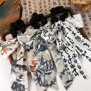 Macro shot of ink wash style hair ties with floral and calligraphy silk ribbons