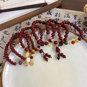 Close-up of cinnabar-style beaded bracelets with traditional Chinese lucky charms and tassels