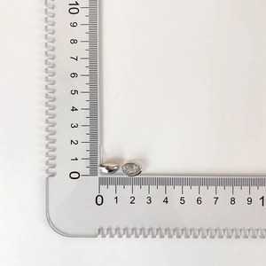 Size comparison showing 8mm silver stud earrings with fine stones against a ruler