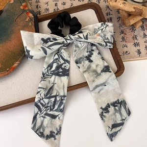 Detail of Chinese style bow scrunchie with ink bamboo patterns on a wooden tray