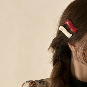 French style wavy acetate hair clip set in red and beige colors worn on side hair