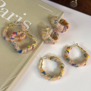 Gros plan de boucles d'oreilles en peluche coeur et rond avec détails en laine